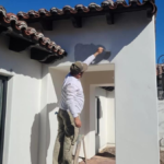Man Painting Stucco Home