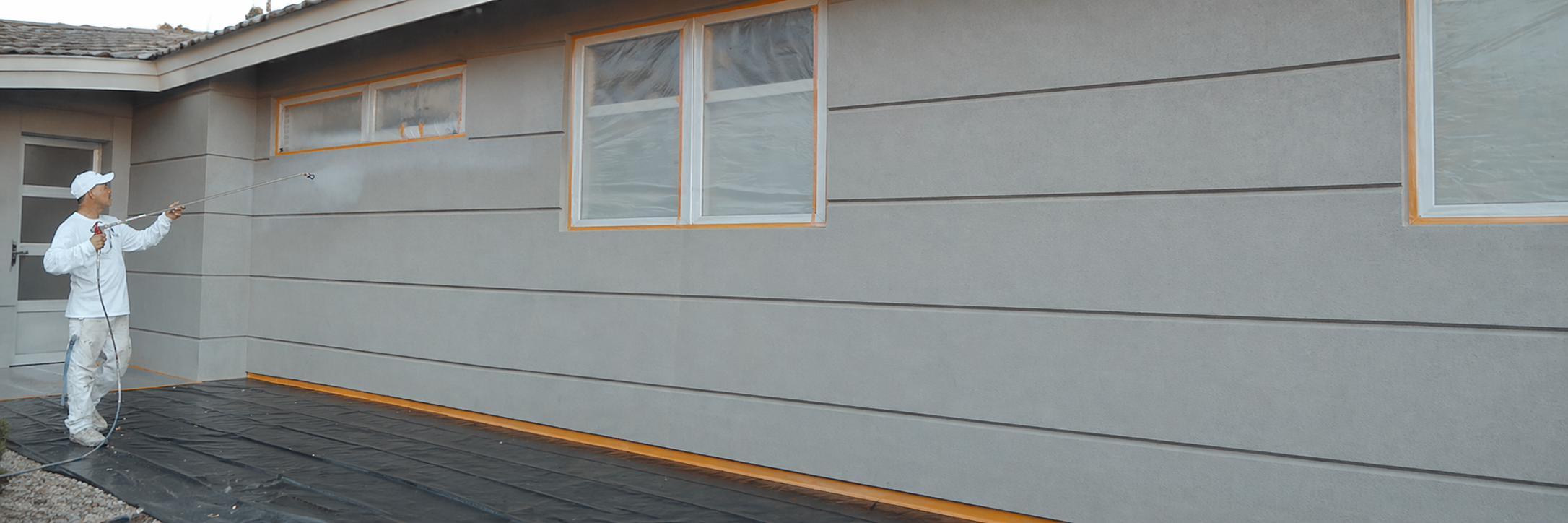 How Much Does It Cost To Paint A House In Phoenix In 2026? Man Spray Painting A House How Much Does It Cost To Paint A House In Phoenix In 2026?